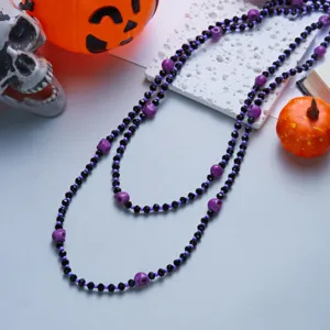 Detail view of double-layered Halloween necklace with purple skulls and black beads