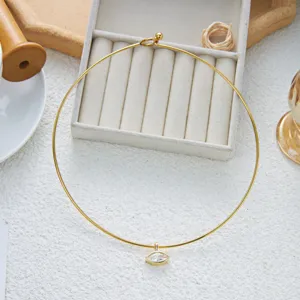Gros plan d'un choker en acier doré avec pendentif marquise en zircone sur fond blanc