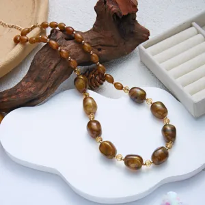 Dettaglio di una collana in resina marrone con perle geometriche a guscio di tartaruga