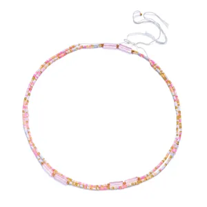 Close-up detail of Bohemian style layered colorful seed bead waist chain on white background