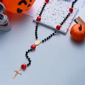 Detailed view of Halloween rosary necklace with red skulls and gold crucifix