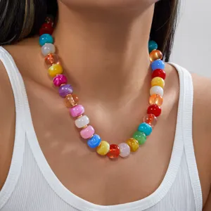 Gros plan d'un collier de perles en acrylique colorées style dopamine porté par un modèle