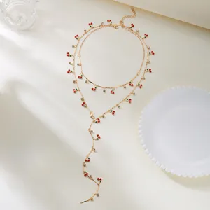 Detailansicht eines modischen, mehrlagigen Kirschhalsketten-Sets in Gold mit Beerenanhängern