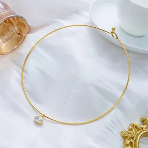 Vue macro détaillée d'un tour de cou en acier doré avec un pendentif ovale en zircon