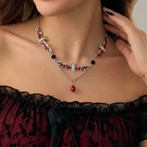 Gothic silver bat necklace with red enamel and teardrop pendant shown on a model