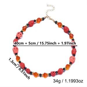 Detail view of red and orange Halloween skull necklace with size and weight specs
