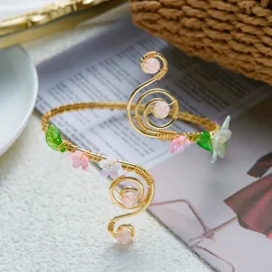 Squisito primo piano di bracciale a spirale in filo d'oro con fiori in acrilico