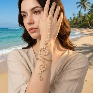 Détail d'un bracelet de bras et de doigt en spirale dorée avec perles sur la plage