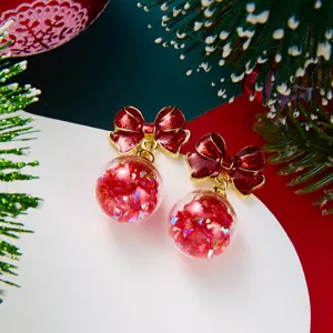 Close-up of festive red bow crystal ball earrings with sparkling red sequins inside.