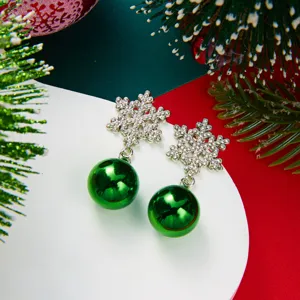 Close-up detail of Christmas snowflake earrings with sparkling crystals and green ornament balls
