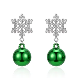 Detailed view of sparkling crystal snowflake earrings with vibrant green ornament ball drops