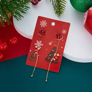 Nahaufnahme von asymmetrischen Goldketten-Ohrringen mit Weihnachtsmann-Anhängern.