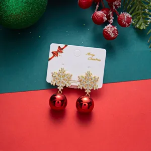 Festive gold snowflake stud earrings featuring vibrant red hanging ornaments for Christmas