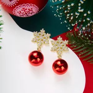 Detailed view of Christmas snowflake earrings with bright red ball pendants and crystals