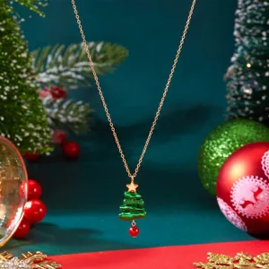 Nahaufnahme einer Halskette mit Weihnachtsbaumanhänger, roter Perle und Stern.