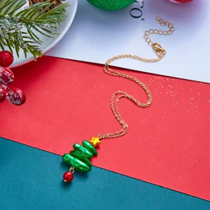 Detailansicht einer Halskette mit Weihnachtsbaumanhänger und festlicher Dekoration