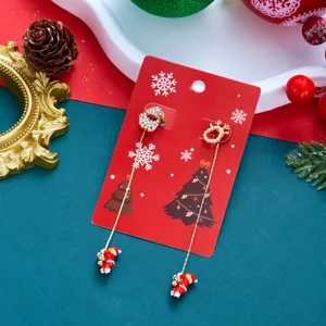 Detailansicht asymmetrischer Weihnachts-Ohrringe auf einer festlichen roten Displaykarte.