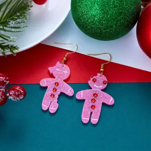 Primo piano di orecchini a forma di omino di pan di zenzero rosa glitterato con strass.