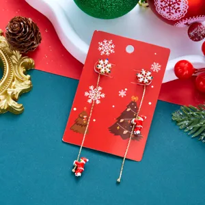 Asymmetrische Weihnachtsohrringe mit Weihnachtsmann und Schneeflocken auf roter Karte.