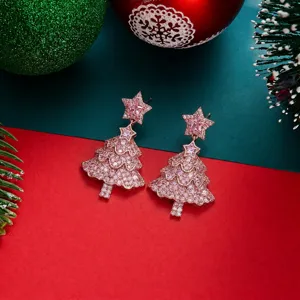 Funkelnde rosa Weihnachtsbaum-Ohrhänger auf festlichem rotem und grünem Hintergrund.