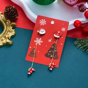 Detailansicht asymmetrischer Weihnachts-Ohrringe mit Weihnachtsmann-Anhängern auf roter Karte.