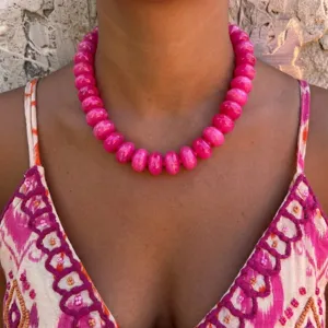 Close-up view of a vibrant hot pink resin beaded necklace in Bohemian style on a model