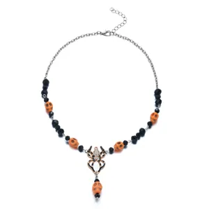 Detailed macro view of a Halloween necklace featuring a spider pendant and orange skull beads