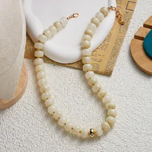 Gros plan d'un collier de perles fait main avec des perles en acrylique texture jade crème