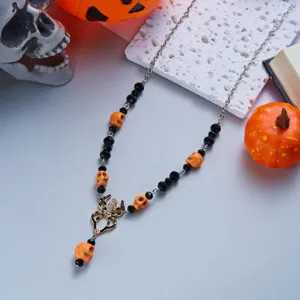 Halloween spider necklace with skull beads and rhinestone details on a thematic background.