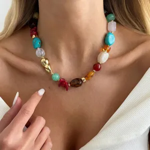 Detailed view of a multi-colored resin beaded necklace worn by a woman in a white top