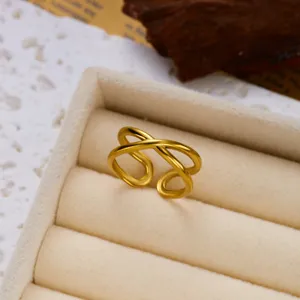 Macro detail of minimalist gold stainless steel double layered crossover ring in box