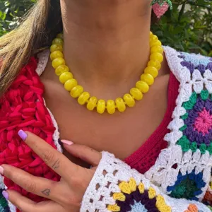 Close-up of yellow resin beaded necklace in bohemian style on model neck