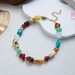 Macro view of colorful irregular resin beads and golden chain of the necklace