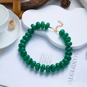 Detailed view of fashionable green resin beaded bohemian necklace on display stand