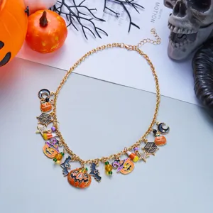 Detailed macro shot of a gold-tone Halloween necklace with pumpkin and bat charms.