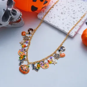 Detail view of Halloween necklace with pumpkin, bat, and spider charms on a gold chain.