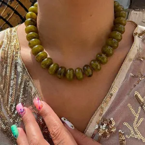 Bohemian style olive green resin beaded necklace on model wearing gold sequin dress