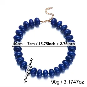 Close-up of bohemian dark blue resin beaded necklace with gold extension chain