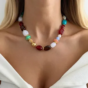 Close-up of a colorful resin beaded necklace with irregular beads and gold spacers