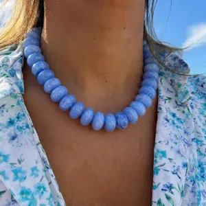 Detail of blue water-ripple resin beaded choker necklace worn on neck