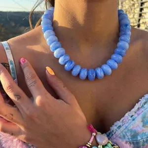 Detailed view of bohemian style chunky blue resin beaded necklace on model neck