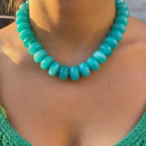 Detailed view of a bohemian chunky turquoise resin beaded necklace worn on a model neck