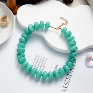 Detailed close-up of Bohemian green marbled resin beaded necklace featuring golden clasp