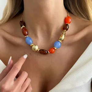 Close-up of a vibrant resin bead necklace with irregular shapes and golden metallic details