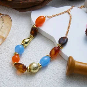 Detailed view of colorful marbled resin beads on a golden bohemian style necklace