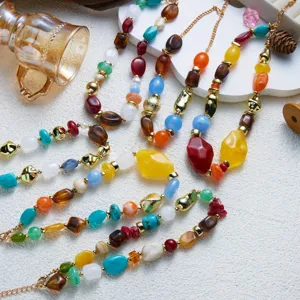 Colorful marbled resin irregular bead necklaces with gold accents on textured background