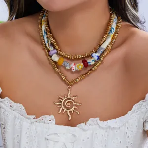 Detalle de collar de capas con cuentas CCB, cerámica, pañuelo de seda y sol dorado
