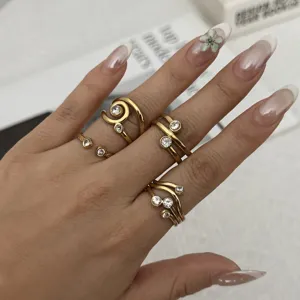 Detailansicht von französischen Vintage-Goldringen mit Zirkonsteinen an der Hand einer Frau