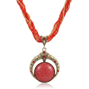 Vista macro dettagliata di una collana vintage bohémien con un grande ciondolo rosso