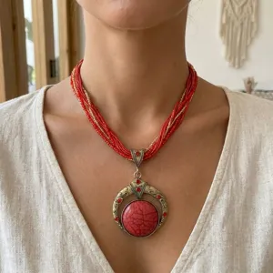 Dettaglio ravvicinato di collana bohémien a più fili con ciondolo vintage decorato